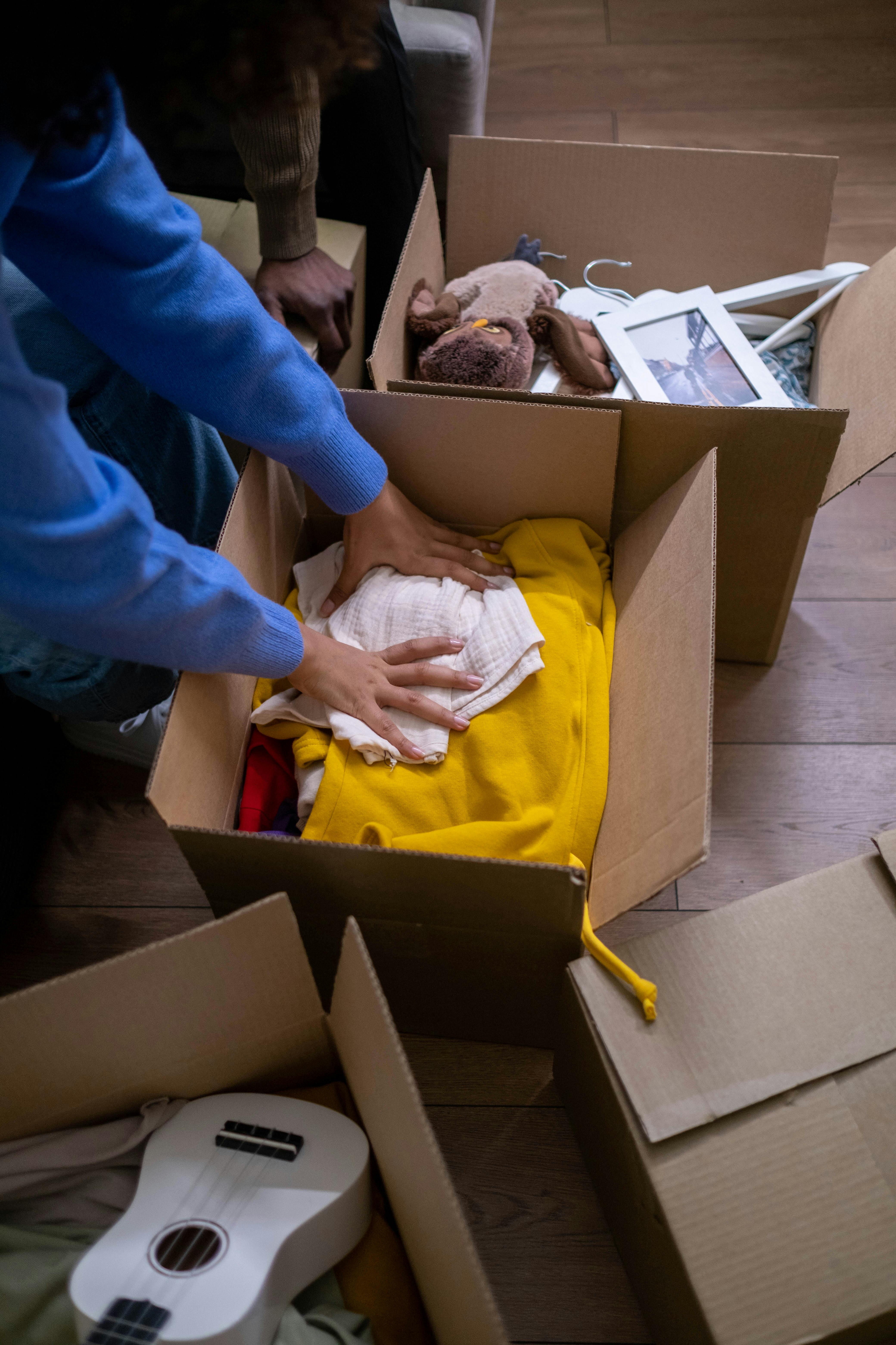 Pessoa organizando caixas de mudança - MUDANÇAS MS